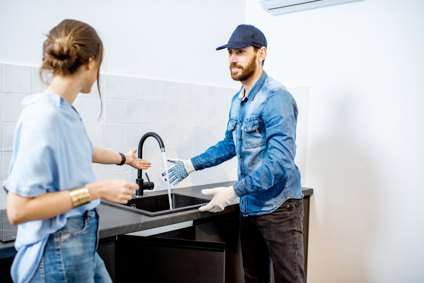 Plumber Fixing Kitchen Sink at a House